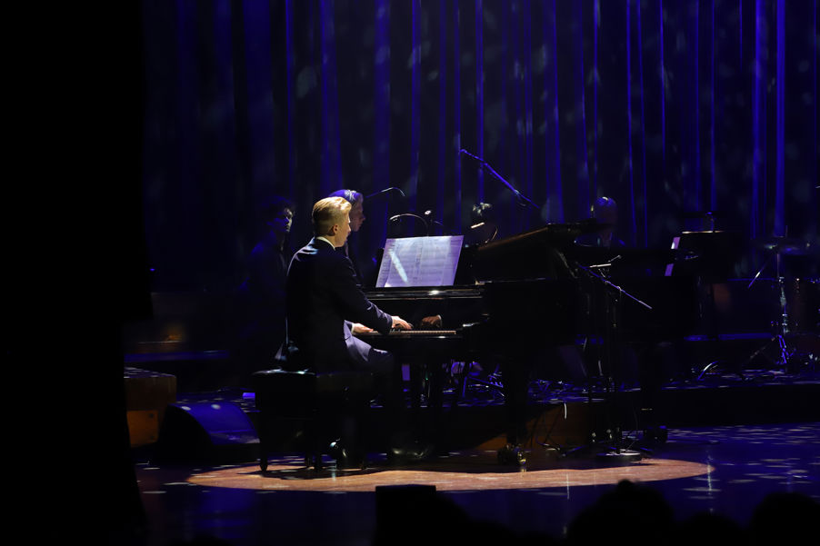 en person som spiller piano på en scene