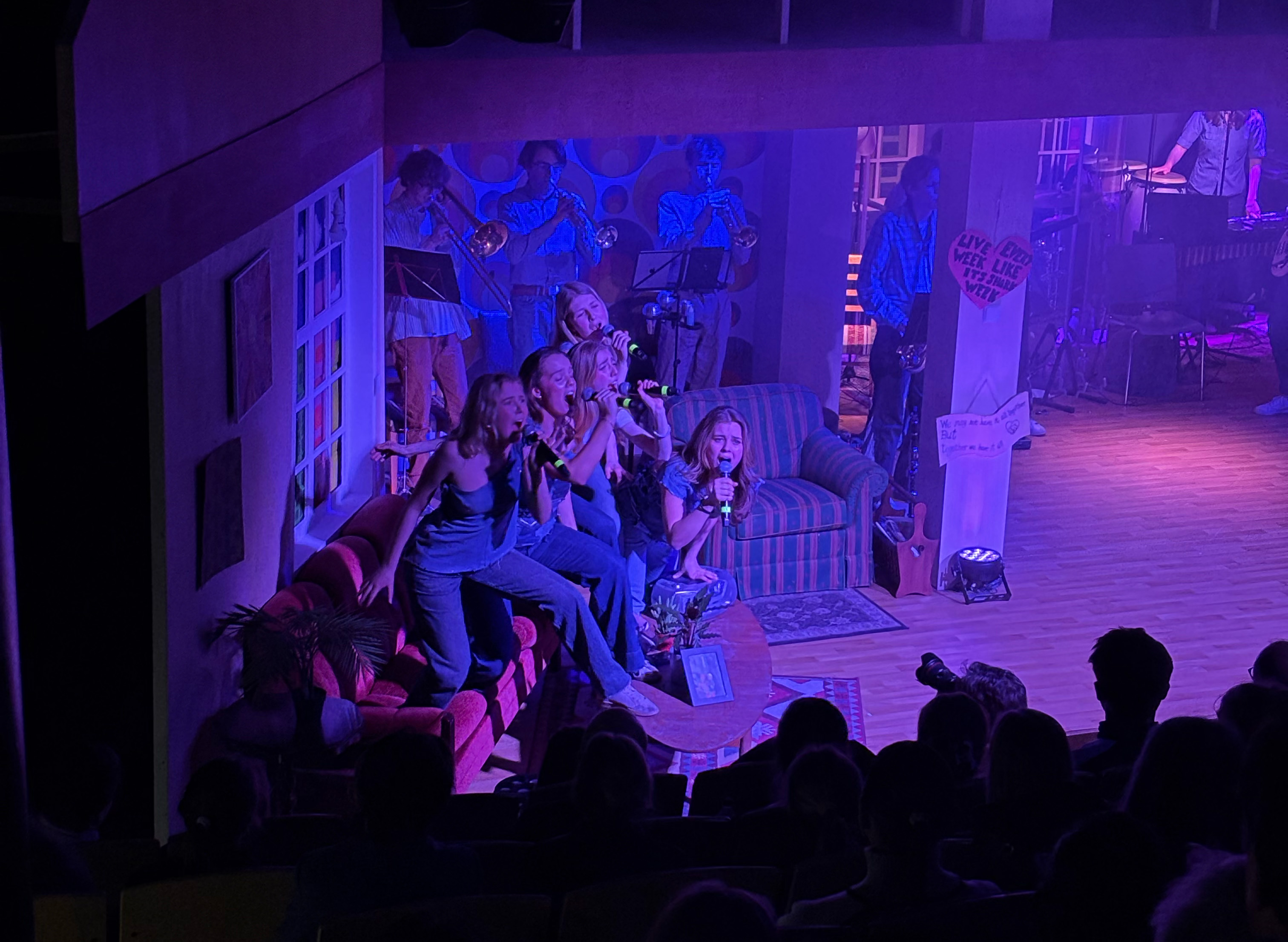 en gruppe mennesker som sitter i et rom med en bærbar datamaskin