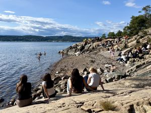 en gruppe mennesker som sitter på en steinete strand