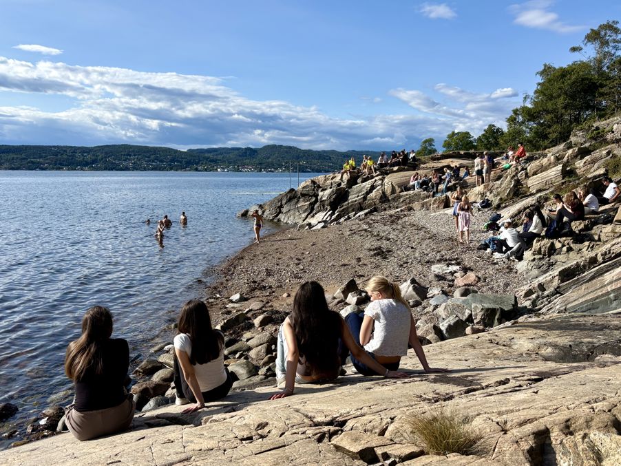 en gruppe mennesker som sitter på en steinete strand